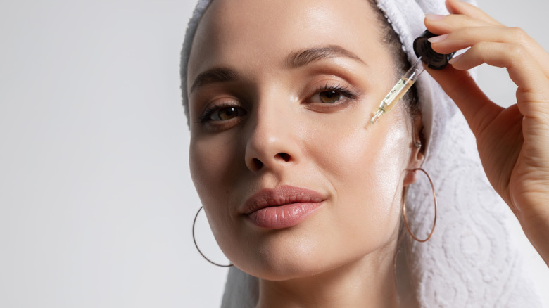 woman applying an oil serum to face