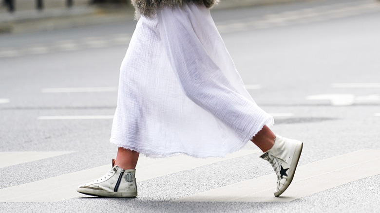 Person walking in Golden Goose sneakers.