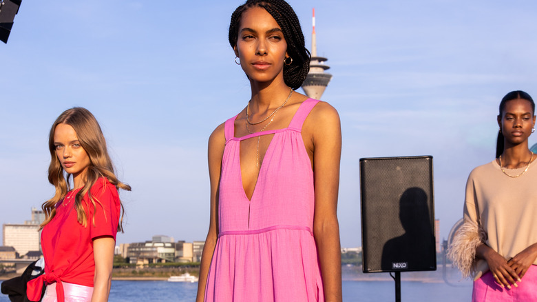 central model wears dress with strap neckline