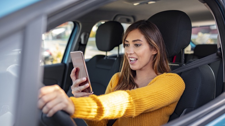 Smiling girl texting and driving
