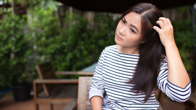 Woman scratching head