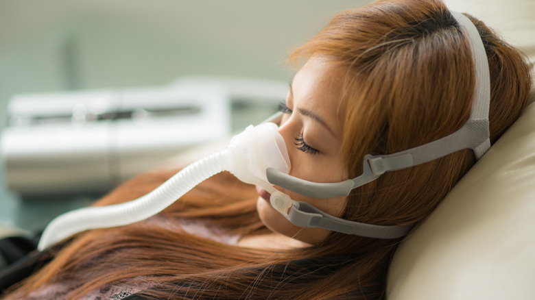Asian woman wearing PAP machine