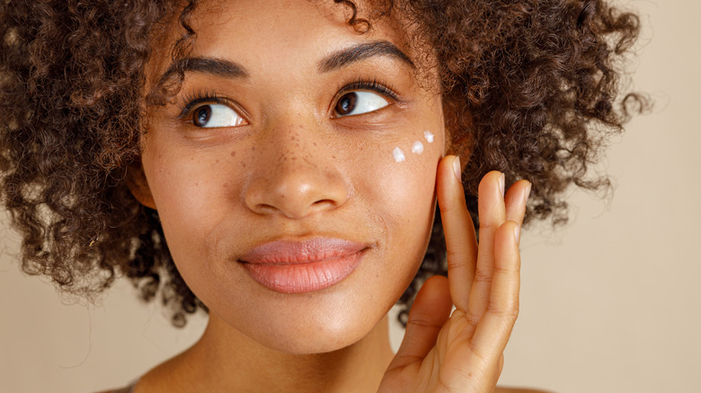 Woman applying moisturizer