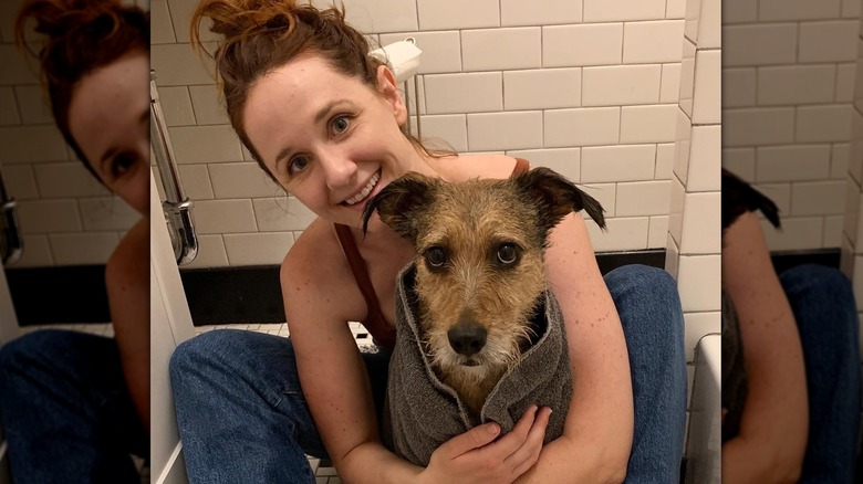 Laura Spencer with her dog posing in a bathroom