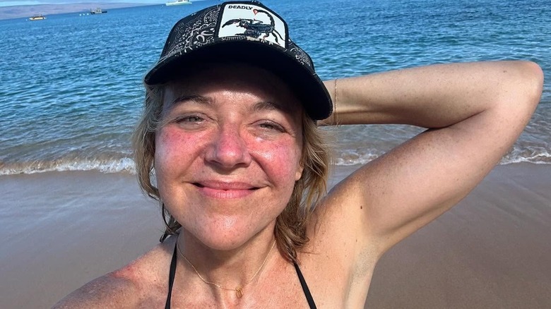 Rachel Bay Jones smiling while fresh-faced at the beach, wearing a cap