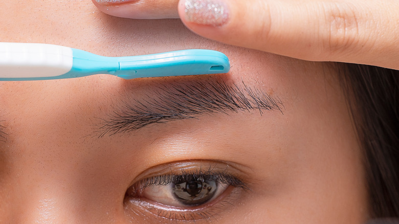 Person shaving their eyebrow