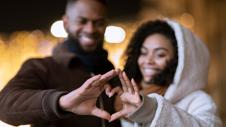 Black couple making heart hands