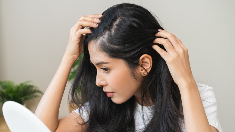 Young woman looking at her hair