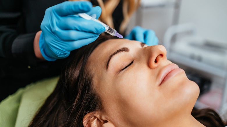 Woman receive injection into forehead