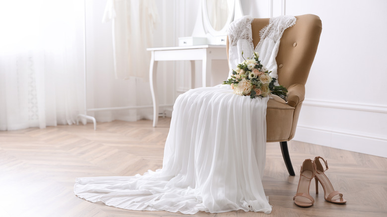 wedding dress laying on a chiar