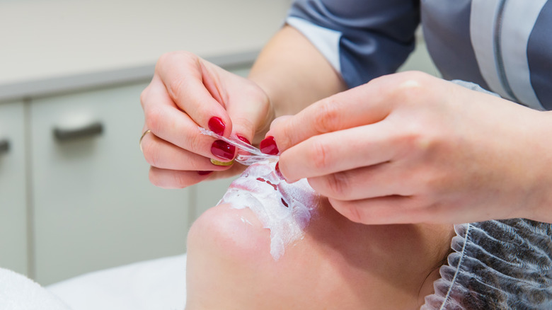Provider applying numbing cream to patient's lips