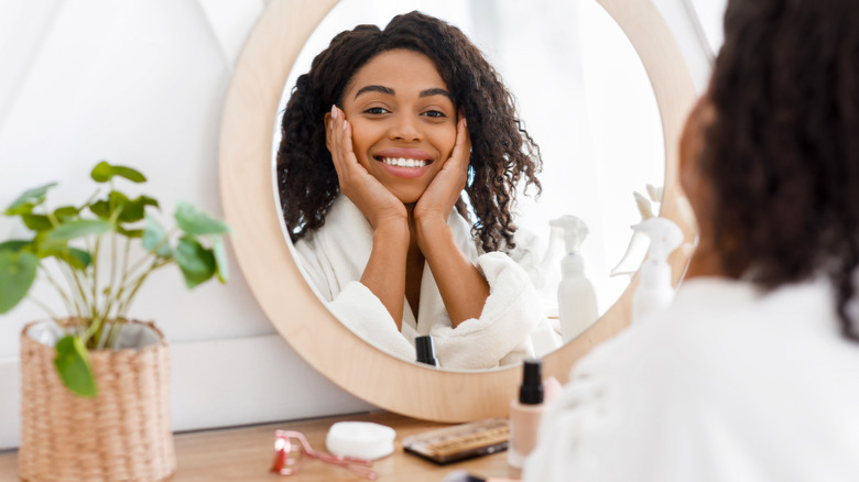 Smiling woman looking in the mirror