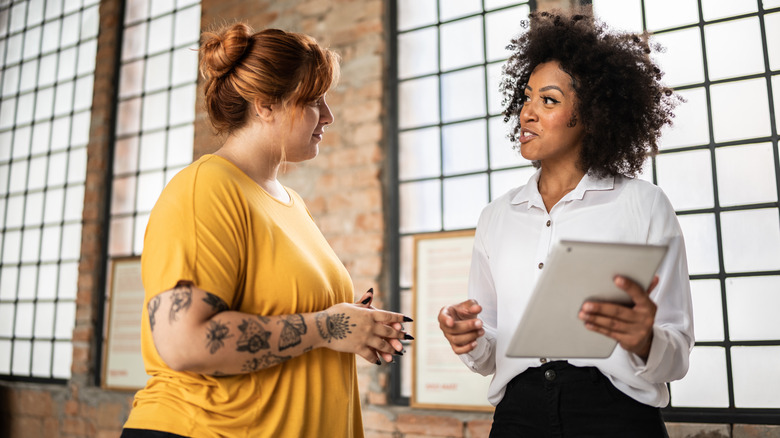 Woman consults tattoo artist