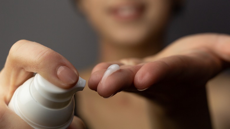 woman putting a cream on her fingers
