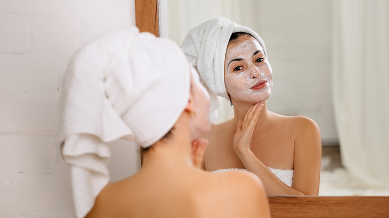woman applying cream to her face