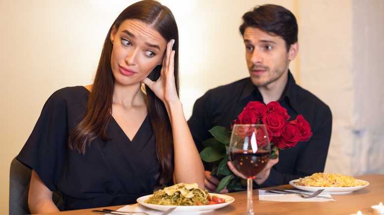 woman embarrassed by man giving her flowers