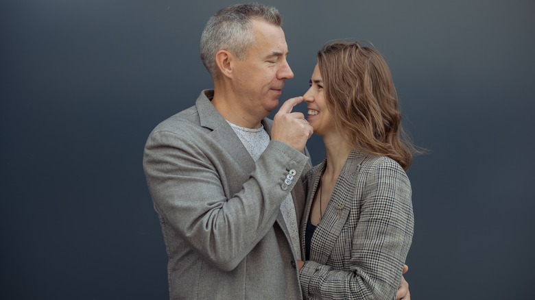 man playfully touching woman's nose