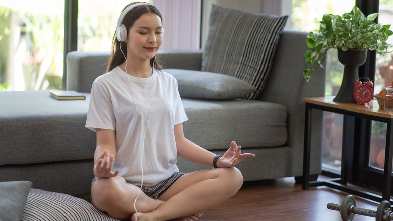 A woman doing yoga and listening to music