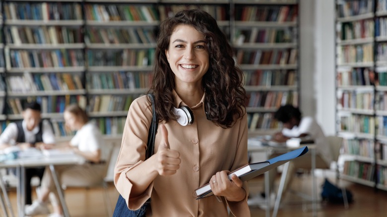Smiling woman in a library studying
