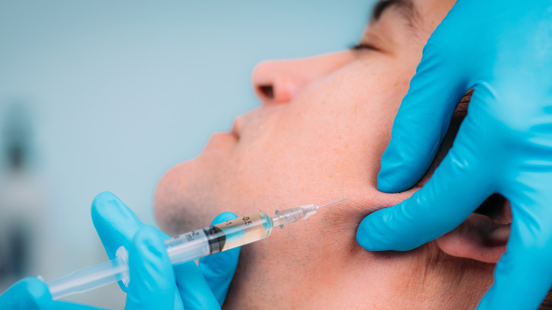 man receiving injections on jaw line