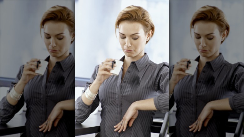 Woman looking down at spill on her blouse