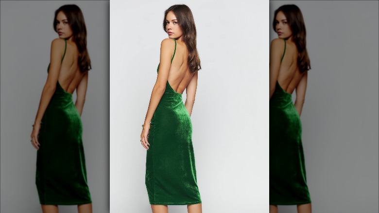 Reformation model wears green velvet midi