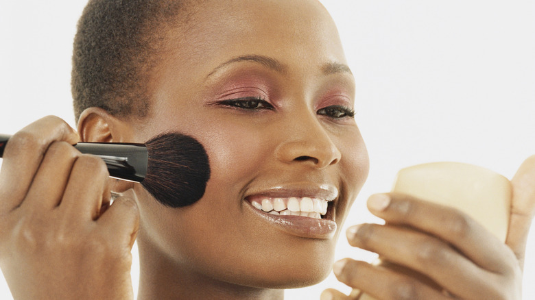 woman applying blush