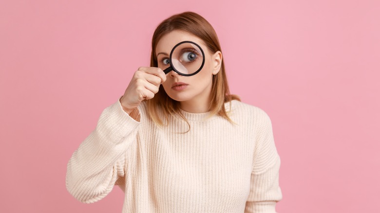 woman holding magnifying glass