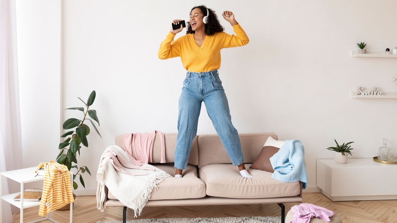 woman singing in messy bedroom