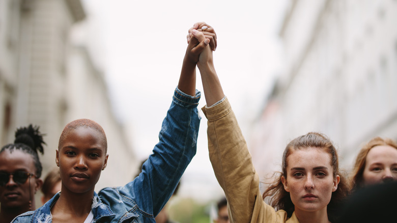 young people holding hands at protest