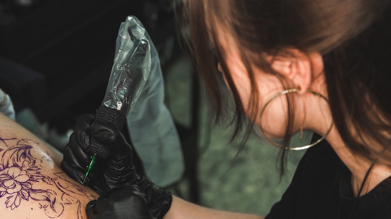 woman giving tattoo