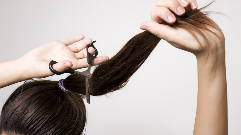 A woman cutting her own hair