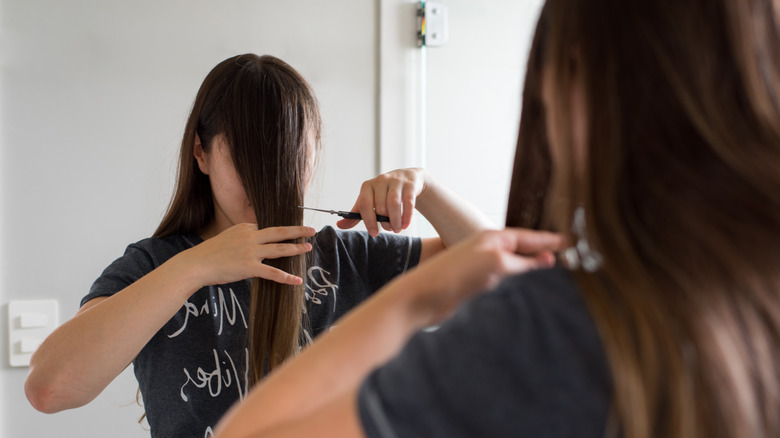 A woman cutting her own hair