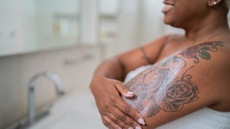 person moisturizing their tattoo