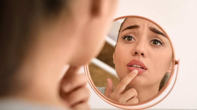 worried woman looking in mirror