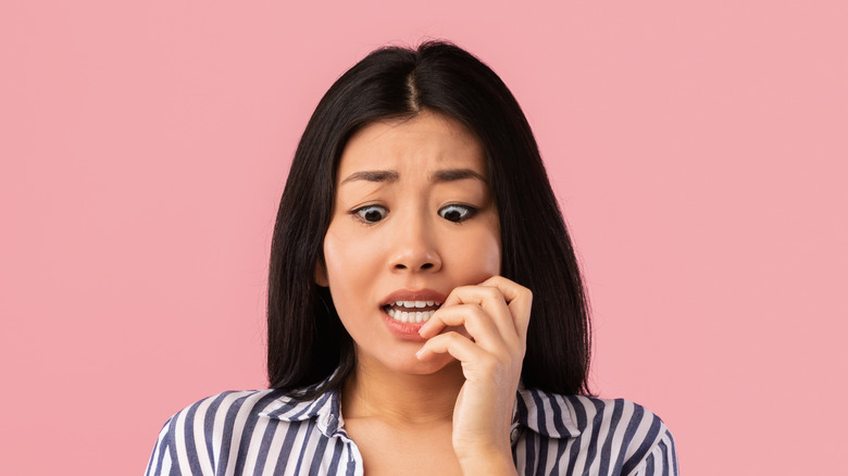 anxious woman biting her nails