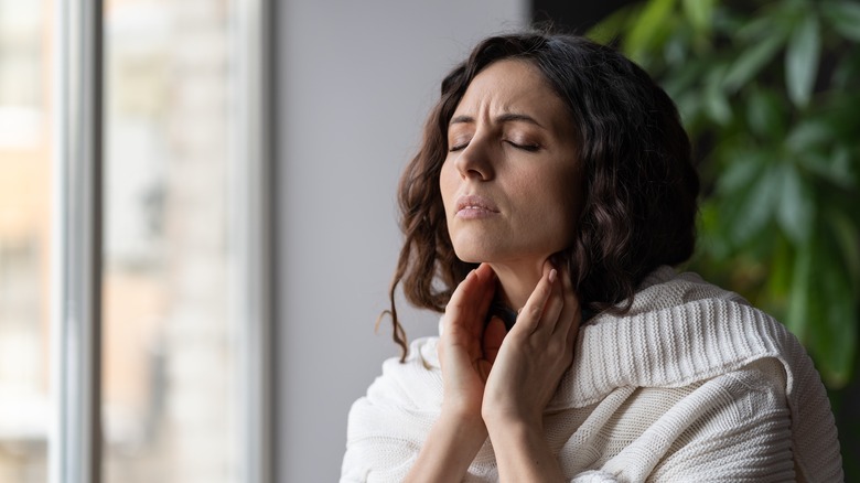 Woman holding throat