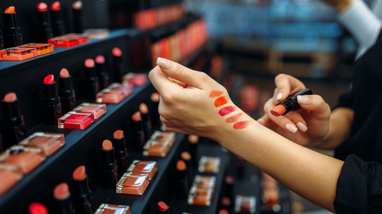 woman trying on lipstick in store