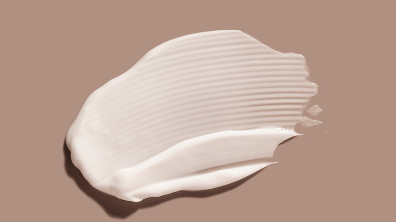 cream product smeared on brown background
