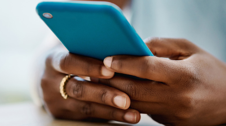 hands holding blue phone 