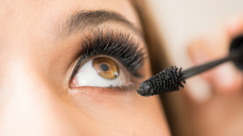 Woman putting on mascara