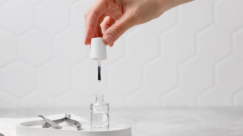 hand with nail polish applicator 