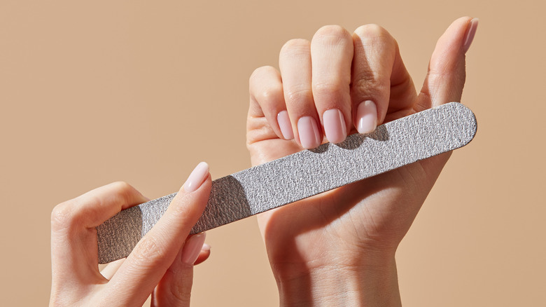 Manicured hands with an emery board