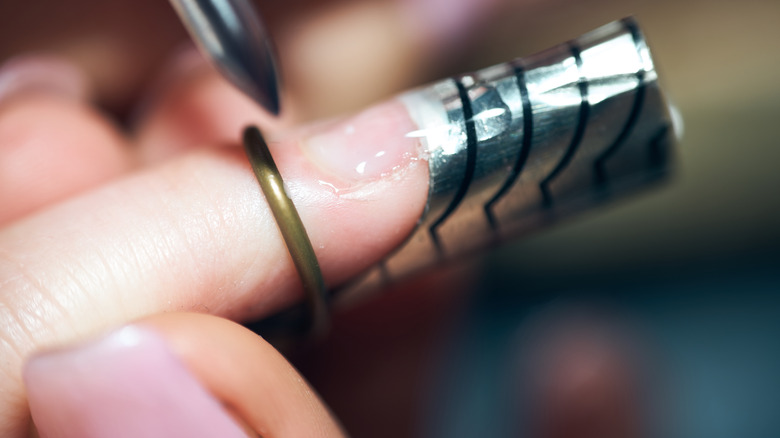 Gel nail extensions being applied