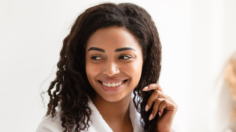 smiling woman touching hair