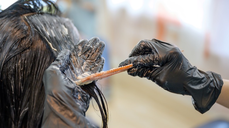 Hairdresser's hands highlighting hair