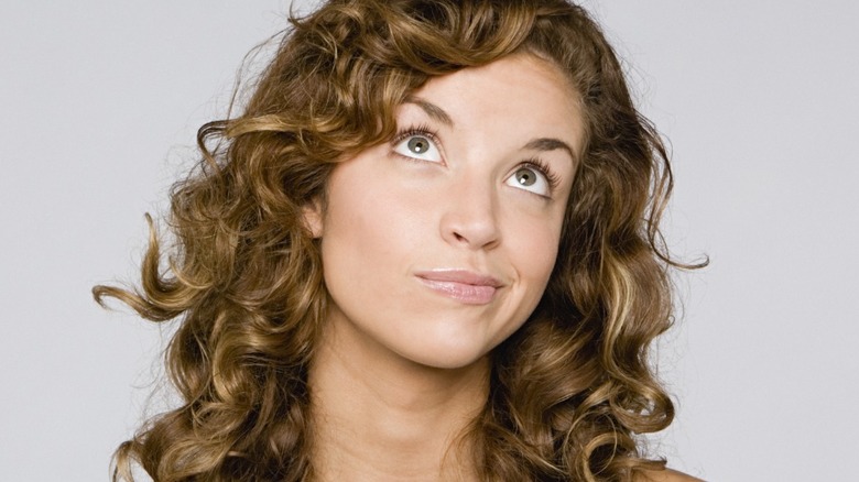 Curly-haired woman thinking