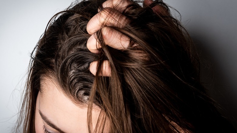 Women holding her greasy hair