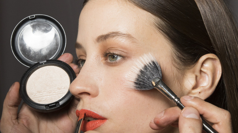 woman getting highlighter applied