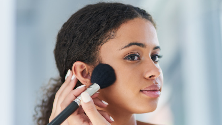 woman applying blush